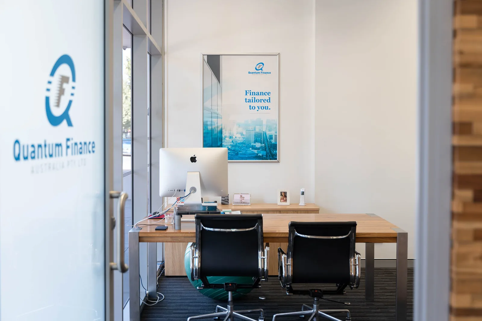 Branded glass doors leading into the meeting rooms at the Quantum Finance office