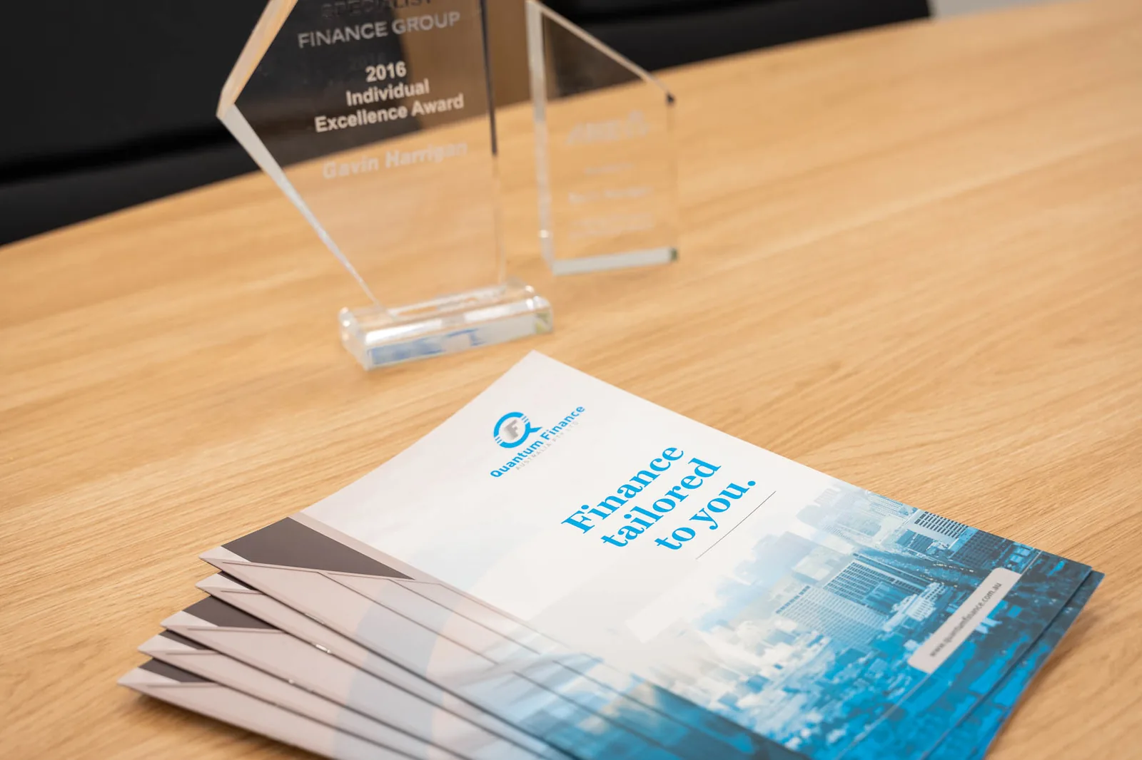 Quantum Finance brochures fanned out across a boardroom table