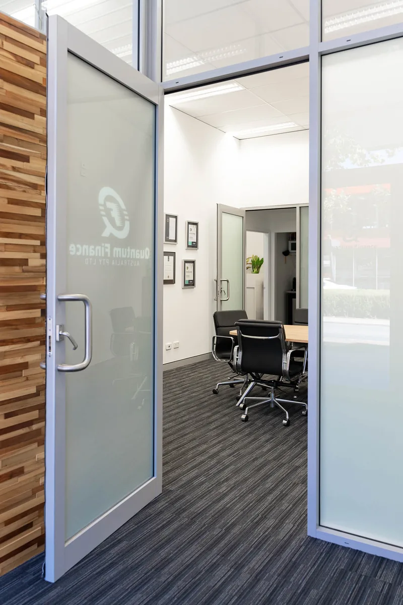 A meeting room at the Quantum Finance office seen through the glass partition
