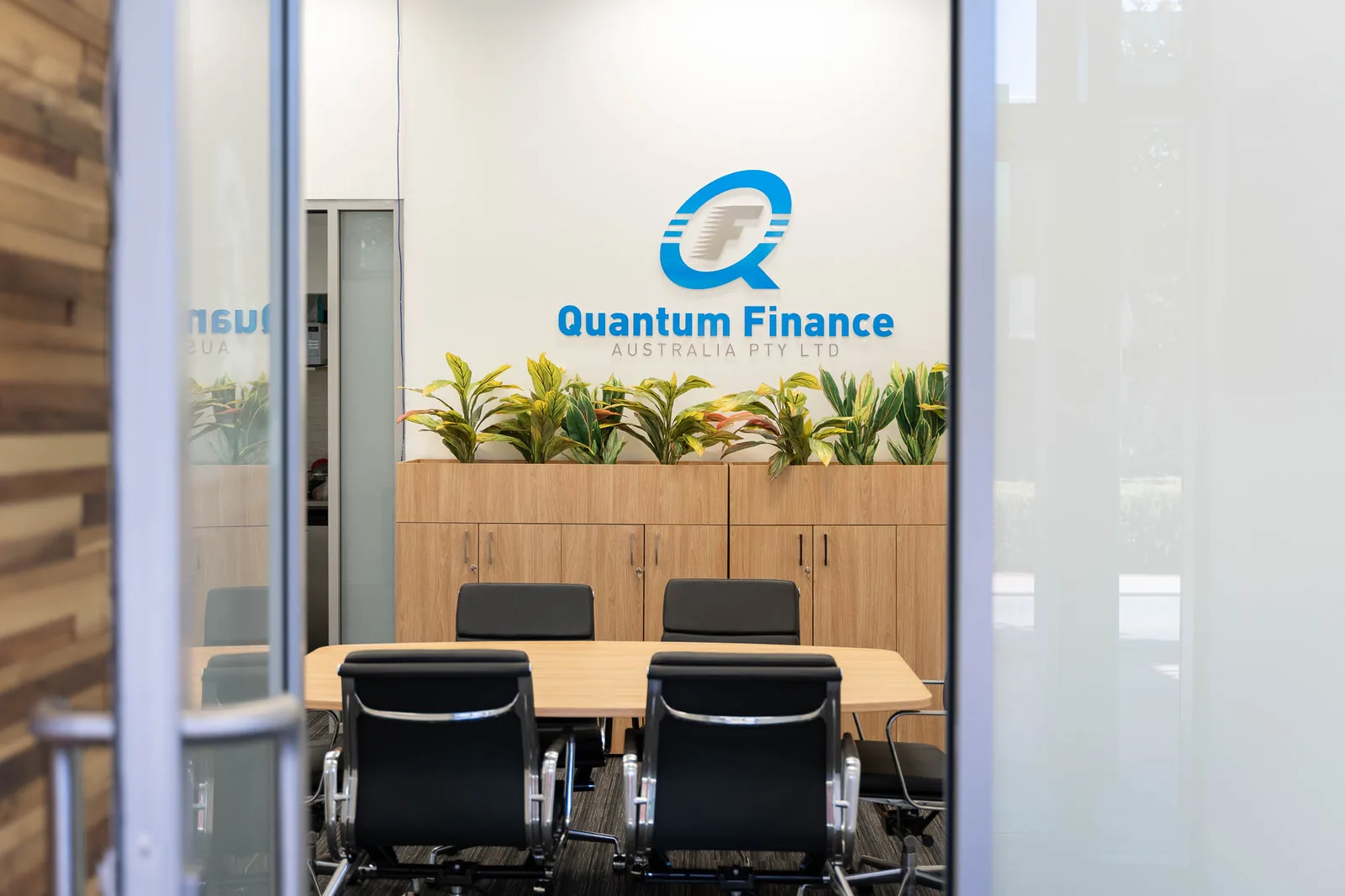 Meeting rooms behind branded glass at the Quantum Finance office
