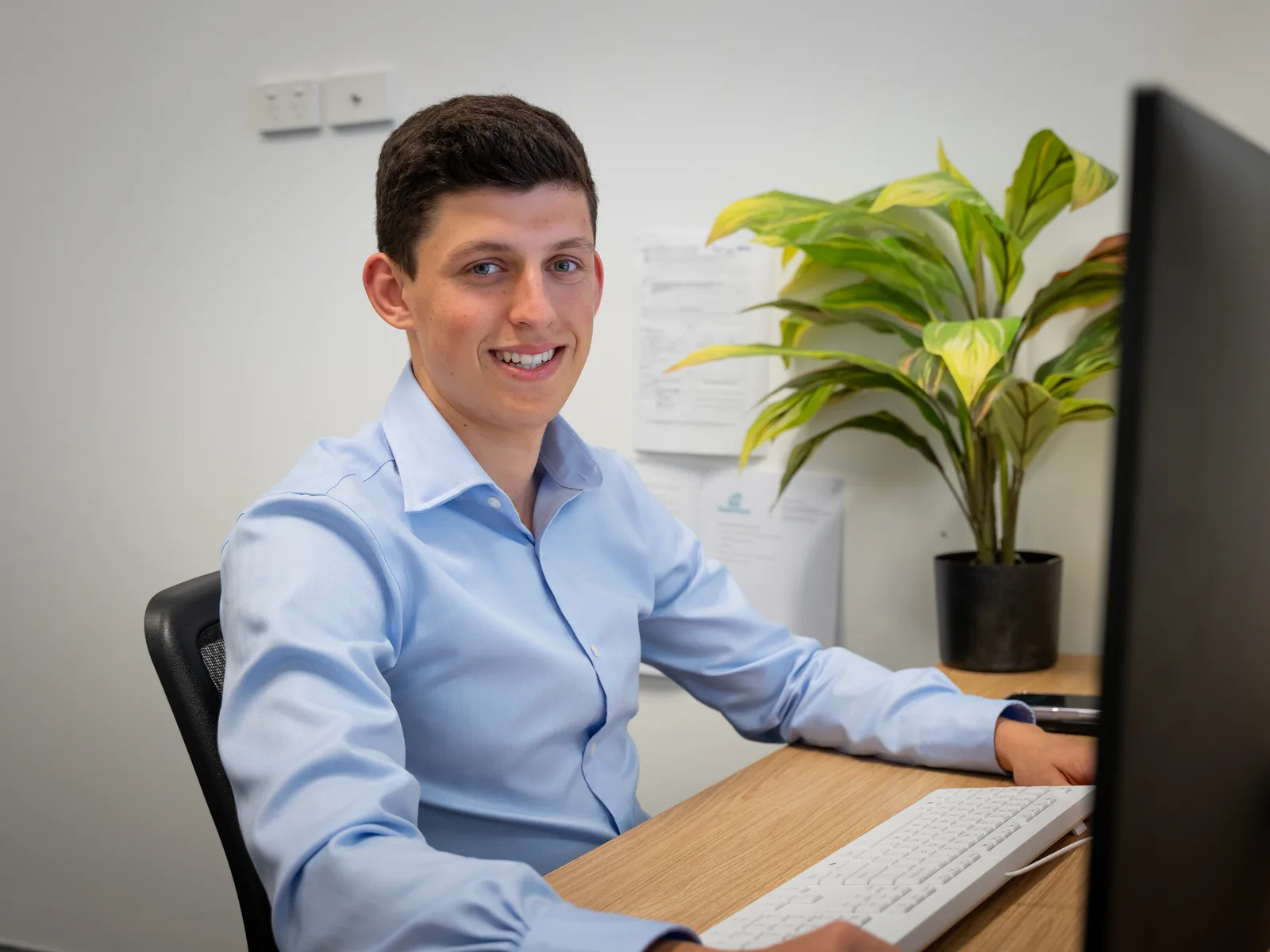 A Quantum Finance broker at his desk comparing home loan products on screen