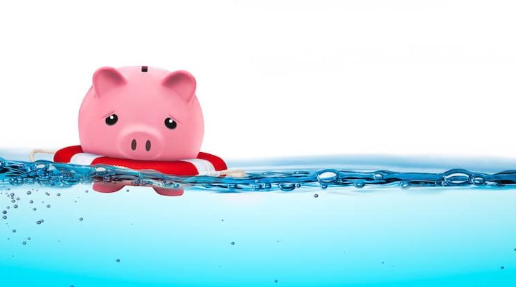 A piggly bank floating just staying above water.