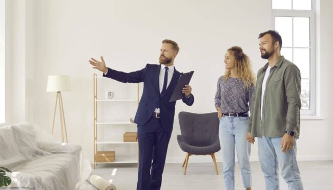 A realtor showing apartment interior to a couple.